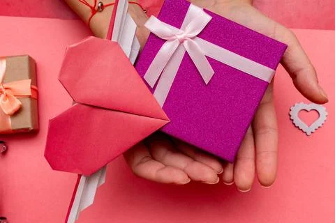 Hands holding present, gift box for Valentine day with heart shape card on th Foto stock