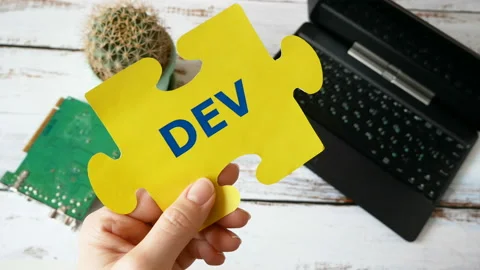 Hands holding puzzle with Dev and Ops words near laptop and motherboard. DevOps  Stock Footage 123145495