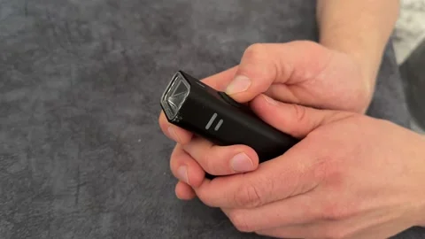 Hands holding rechargeable electric lighter with indicator lights, modern Stock Footage 337121015