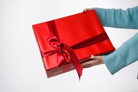 Hands holding red gift box with ribbon on white background, copy space Stock Photos