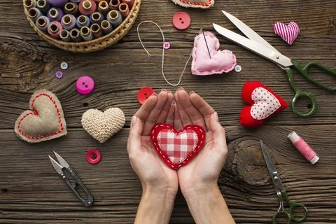 Hands holding a red heart shape on wooden background Stock Photos