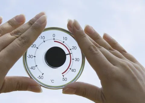 Hands holding a round thermometer Stock Photos