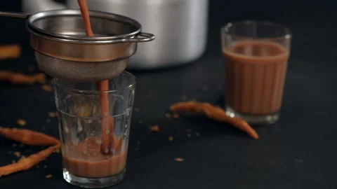 Hands holding a sieve to strain the tea pouring it into a transparent glass -... Stock Footage 157303670