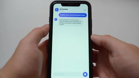 Hands holding smartphone with AI chatbot explaining neural networks on screen Stock Footage 341405930