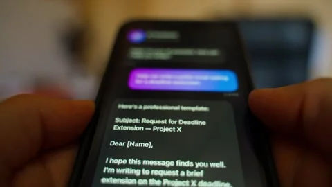 Hands holding smartphone asking AI assistant to write polite email about Stock Footage 342129244