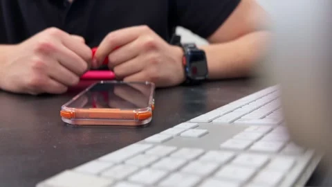 Hands Holding Smartphone Behind Blurred Computer Keyboard Stock Footage 337618352
