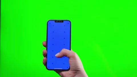 Hands holding smartphone with blue screen on green background. Stock Footage 321603217