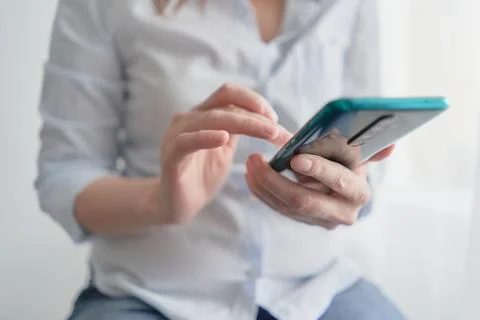 Hands holding smartphone with glowing screen girl looking for information in a Stock Photos