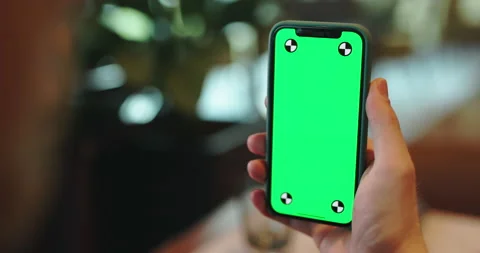 Hands holding smartphone with green screen. man having a video chat on a phone Stock Footage 233103589