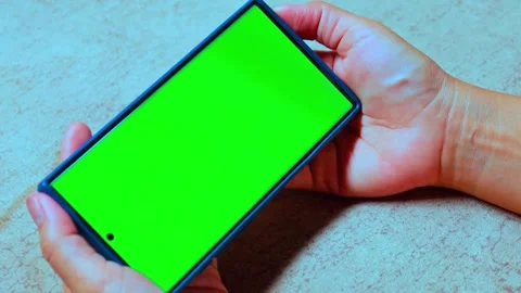 Hands holding smartphone with green screen chroma key display on tabletop Stock-Footage 341802003