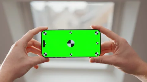 Hands Holding Smartphone with Green Screen in Front of Window for Chroma Key Use Stock Footage 345846844