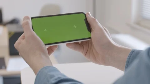Hands holding smartphone horizontal with greenscreen Stock Footage 125693260