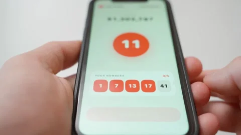 Hands holding smartphone with lottery app drawing numbers and winning prize Stock Footage 342129658