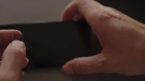 Hands holding smartphone sim card tray and inserting into smartphone Stock Footage 321401850