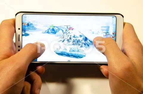 Hands holding a smartphone on which the game, gameplay Gameplay World of Tank Stock Photos