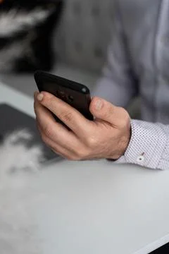 Hands holding smartphone at workplace Stock Photos