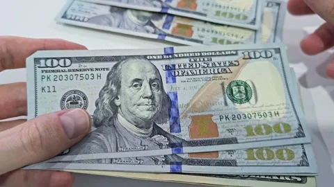 Hands holding stack of US one hundred dollar bills Stock Footage 310892416