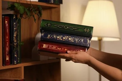 Hands holding stack of vintage ornate books, classic literature and education Stock Photos