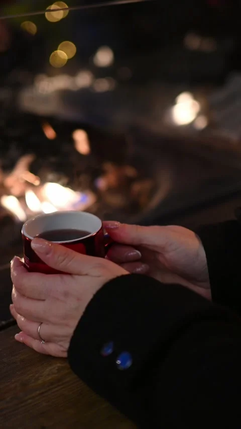 Hands Holding a Steaming Hot Drink by the Fire at a Christmas Market Stock-Footage 318184575