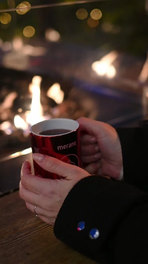Hands Holding a Steaming Hot Drink by the Fire at a Christmas Market Stock-Footage 318184594