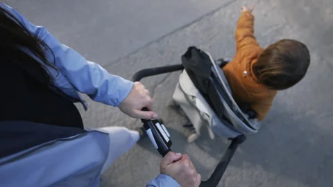 Hands holding stroller POV of mother walking outside in nature with baby. P.. Stock Footage 249283907