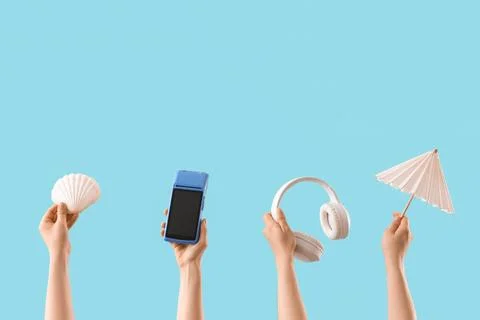 Hands holding summer and technology items on blue background Stock Photos