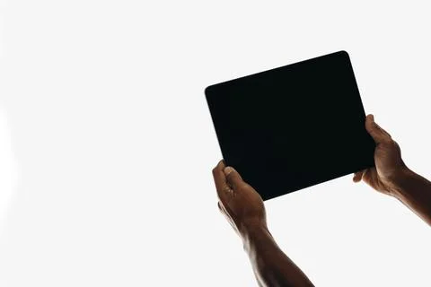 Hands holding a tablet with a blank screen on a plain white background Stock-Fotos