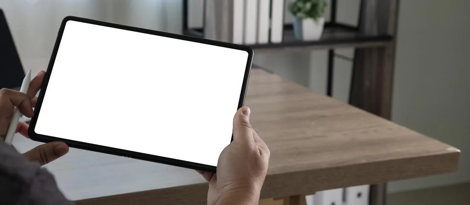 Hands holding tablet with blank screen while using stylus for interface des.. Stockfoto's