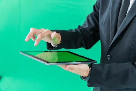 Hands holding tablet computer on light green background Stock Photos