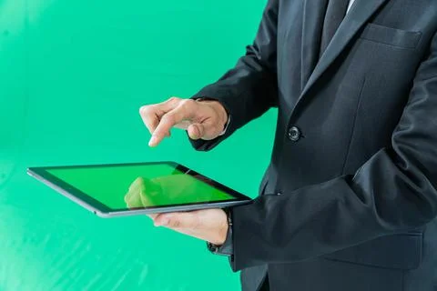 Hands holding tablet computer on light green background Stock Photos