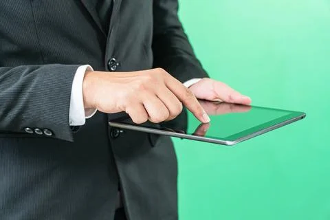Hands holding tablet computer on light green background Stock Photos