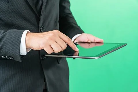 Hands holding tablet computer on light green background Stock Photos