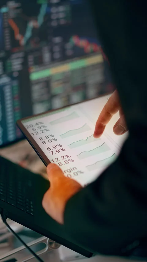 Hands Holding Tablet Displaying Financial Growth Charts and Trading Data Stock Footage 341570107