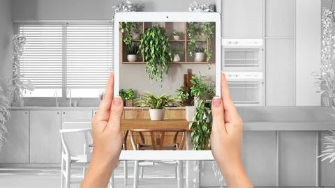 Hands holding tablet showing kitchen and dining room, total blank project b.. Stock Illustration