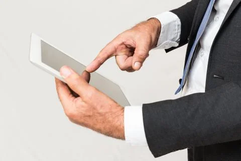 Hands holding a tablet touch pad computer gadget and touches the screen Stock Photos
