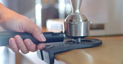 Hands holding tamper coffee pressed into the horn holder. Stock Footage 223209564