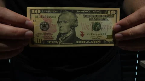 Hands Holding Ten US Dollar Bill Close Up In Dark Setting Stock Footage 339972025