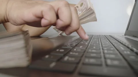 Hands holding of thousands Thai baht banknotes money and working with laptop. Stock Footage 236014633