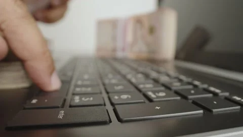 Hands holding of thousands Thai baht banknotes money and working with laptop. Stock Footage 238503653