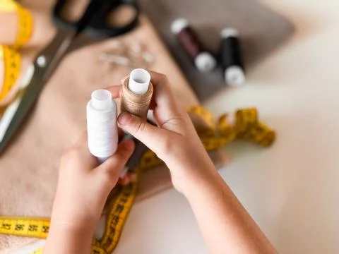Hands holding thread spools for sewing with tape measure and fabric Stock Photos