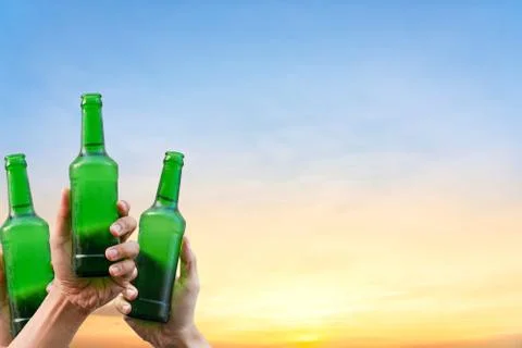 Hands holding three beer bottles Stock Photos