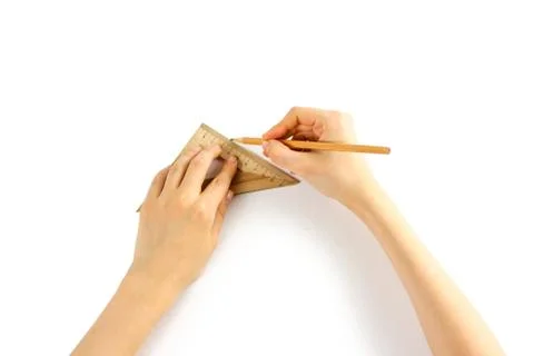 Hands holding a triangular ruler and pencil on a white background. Closeup Fotos de archivo