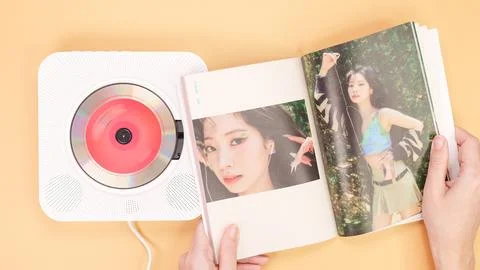 Hands holding Twice Between 1 and 2 mini Album photobook on yellow. Music C.. Stock Photos