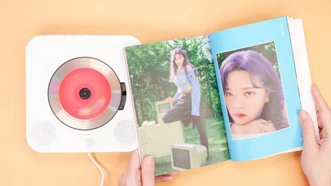 Hands holding Twice Between 1 and 2 mini Album photobook on yellow. Music C.. Stock Photos