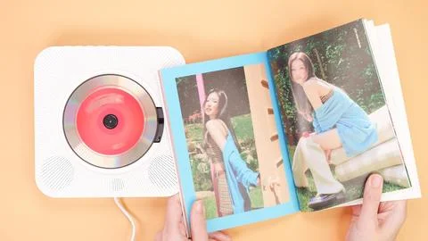 Hands holding Twice Between 1 and 2 mini Album photobook on yellow. Music C.. Stock Photos