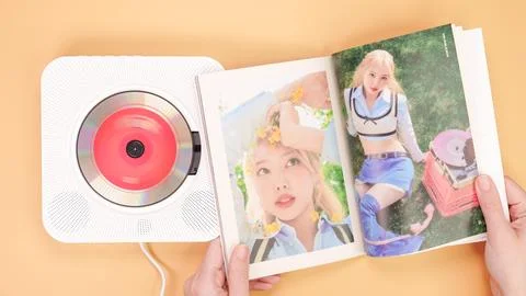 Hands holding Twice Between 1 and 2 mini Album photobook on yellow. Music CD Stock Photos