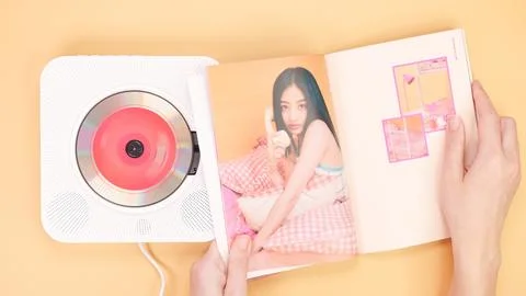 Hands holding Twice Between 1 and 2 mini Album photobook on yellow. Music CD Stock Photos