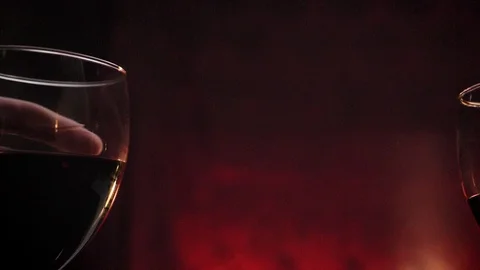 Hands holding two glasses of red wine during date, romantic dark red background Video stock 91874989