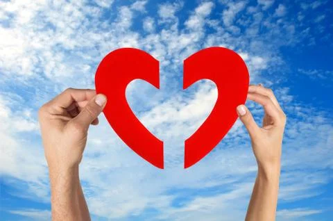 Hands holding two half of heart shape with blue sky background Stock Photos