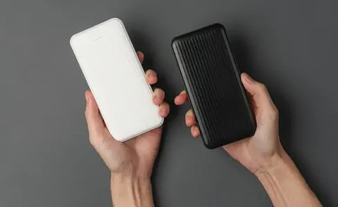 Hands holding two portable external hard drives on dark background Stock Photos
